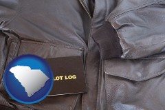 south-carolina map icon and an leather aviator jacket and pilot log book