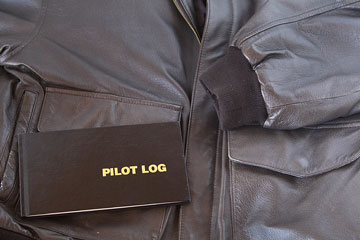 an leather aviator jacket and pilot log book